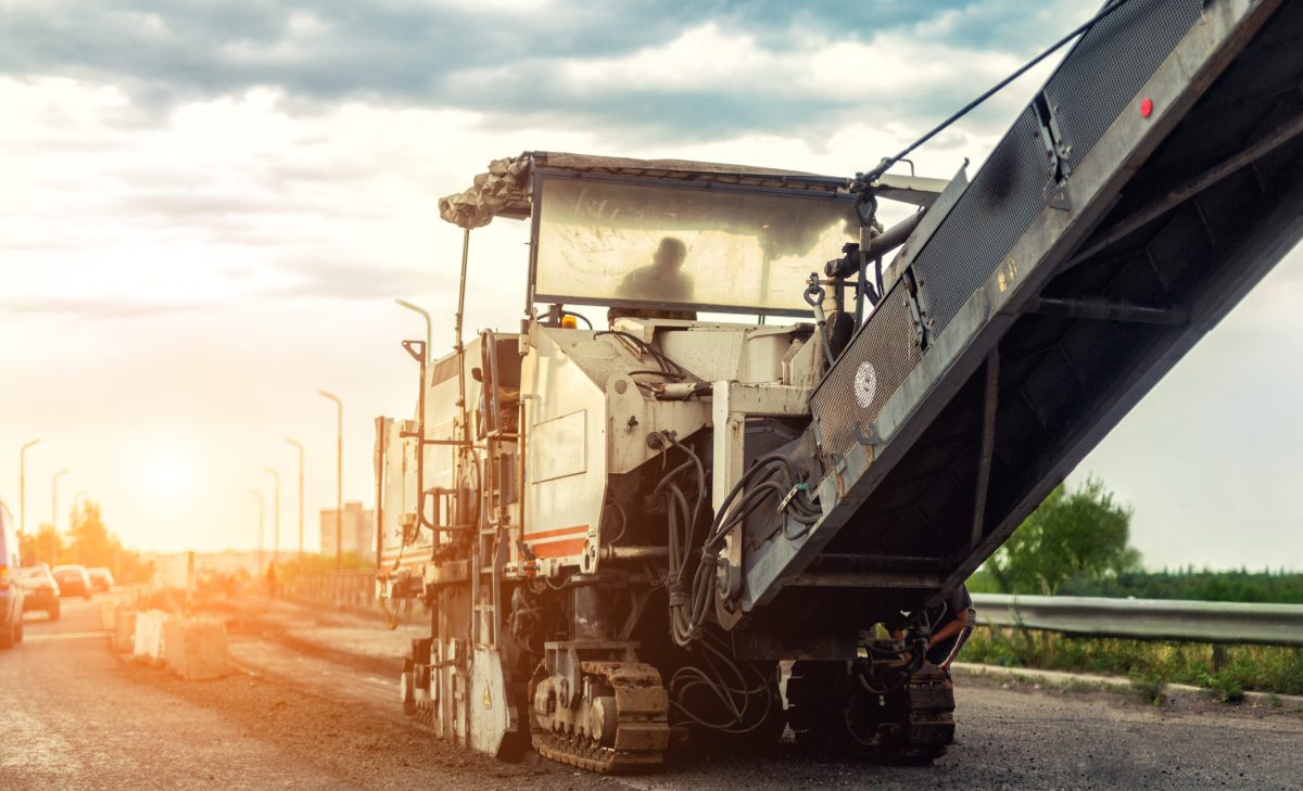 Asphalt milling and grinding machine at road repair and construction site. Highway renewal with heavy machinery Asphalt milling and grinding machine at road repair and construction site. Highway renewal with heavy machinery.